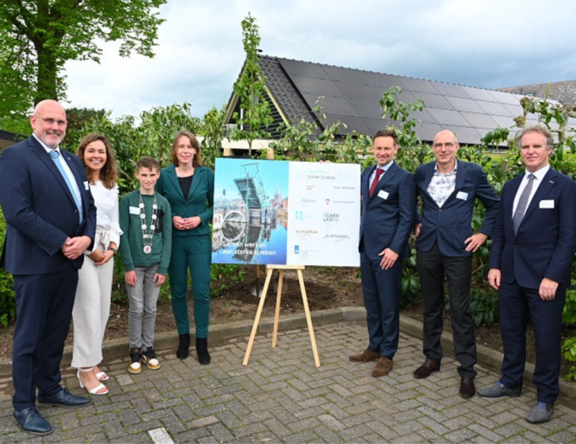 Minister Hanke Bruins Slot staat naast een bord waar op de ondertekening van de Town Deal is vastgelegd